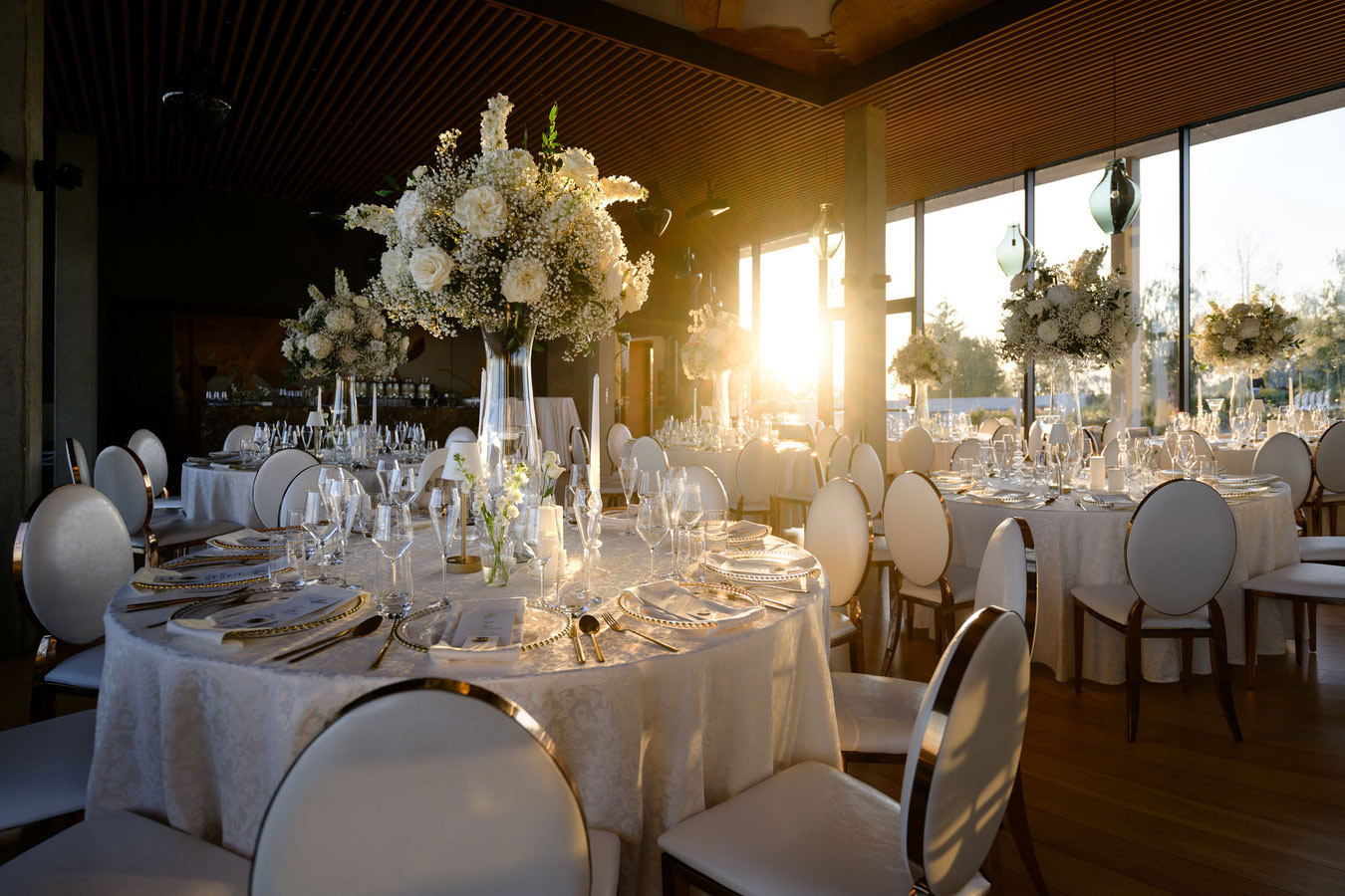 Luxusně nazdobená svatební tabule při západu slunce v moderním prostředí, elegantní detail zachycený svatebním fotografem Praha