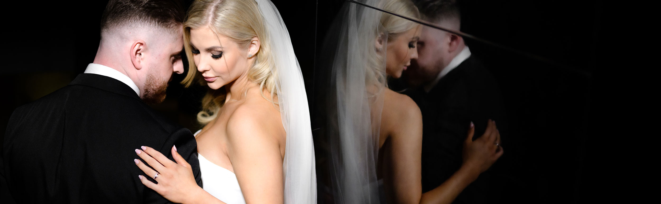 nevěsta s ženichem u černé zrcadlové zdi