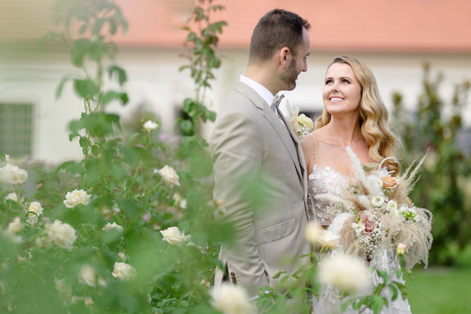 Romantický portrét nevěsty a ženicha v růžové zahradě svatebního místa Na Kmíně – elegantní letní svatba s přírodní květinovou výzdobou, zachyceno Jindřich Nejedlý Photography.