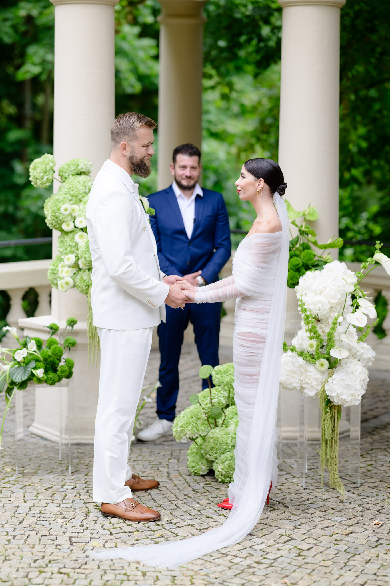 Debbie Brown’s wedding in Karlovy Vary: the fashion designer in a sheer dress exchanging vows with the groom at Villa Julius & Emma P. Romantic floral decoration.