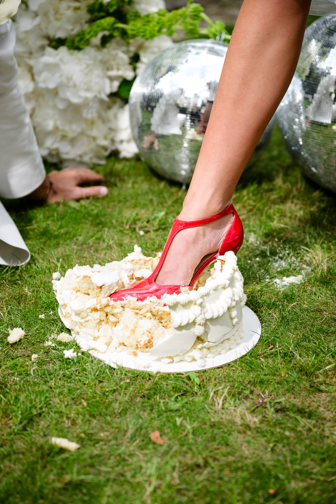 Debbie Brown’s wedding: the fashion designer playfully steps on the wedding cake with a red heel on the lawn. A joyful celebration with a disco ball and floral décor in Karlovy Vary.