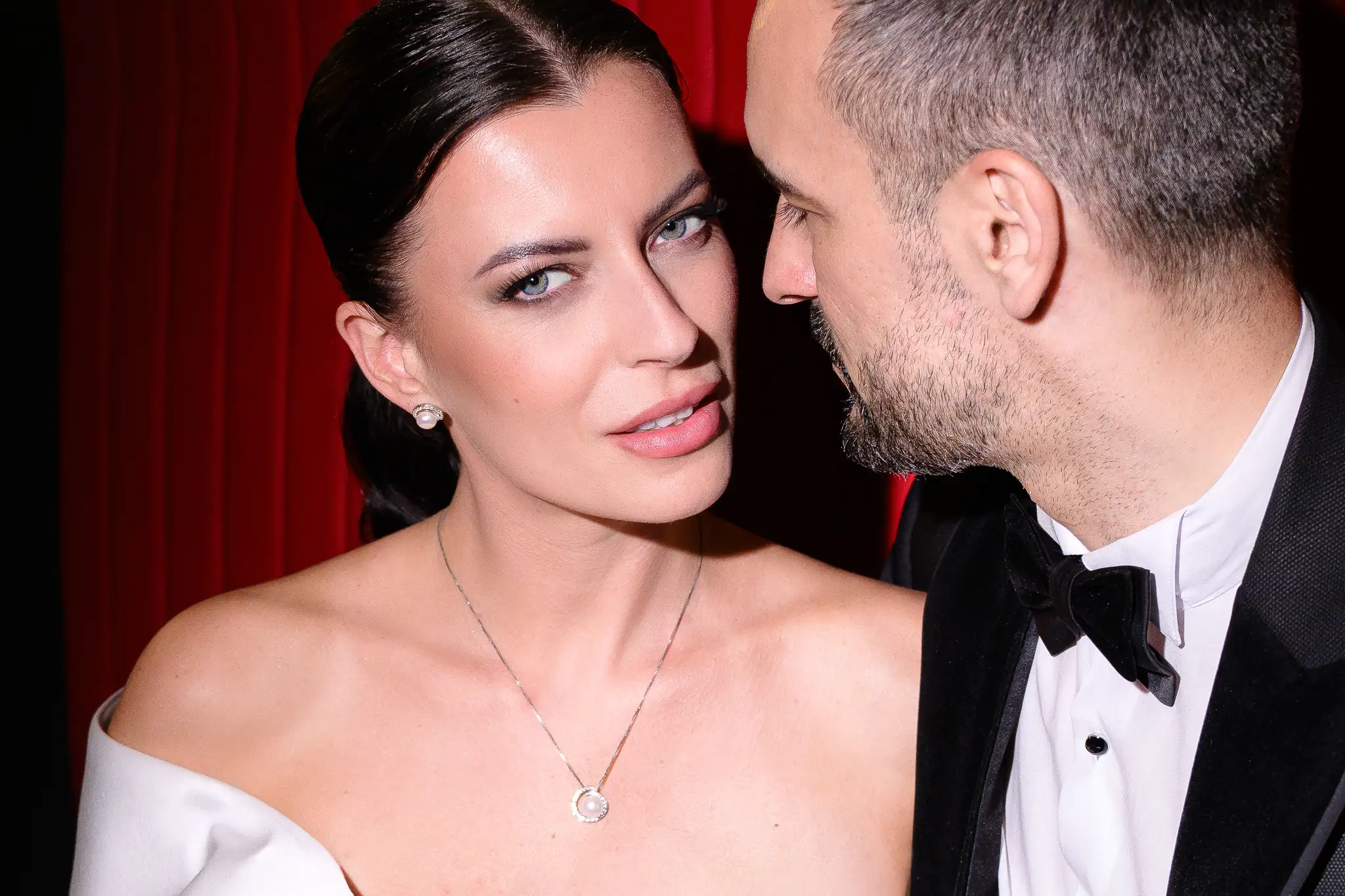 Bride and groom in an intimate close-up, red background, wedding editorial Hotel Passage Brno