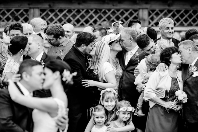 group of wedding guests kissing