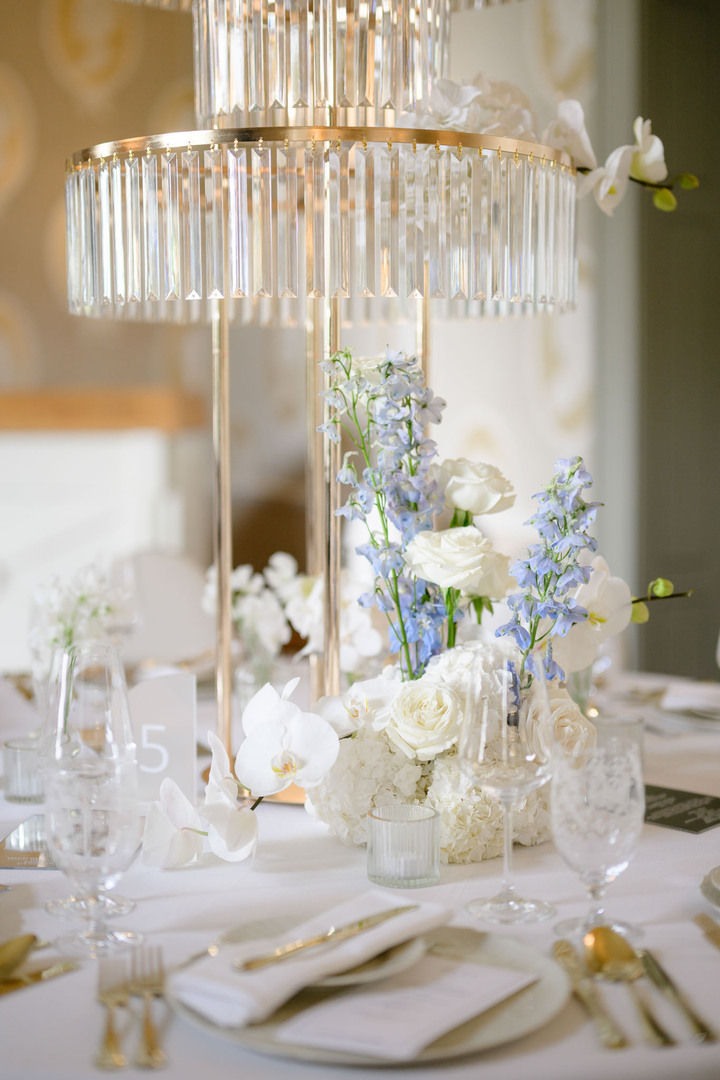 Elegant wedding reception table with crystal centerpiece and white floral arrangements at Chateau Mcely.