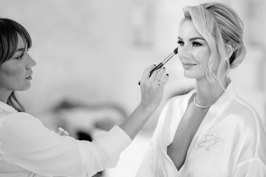 Bride getting makeup applied by a professional makeup artist at Chateau Mcely