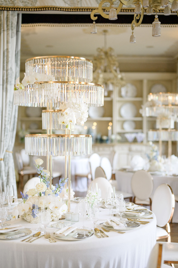 Luxurious wedding table setting with crystal decor, white roses, and blue accents at Chateau Mcely.