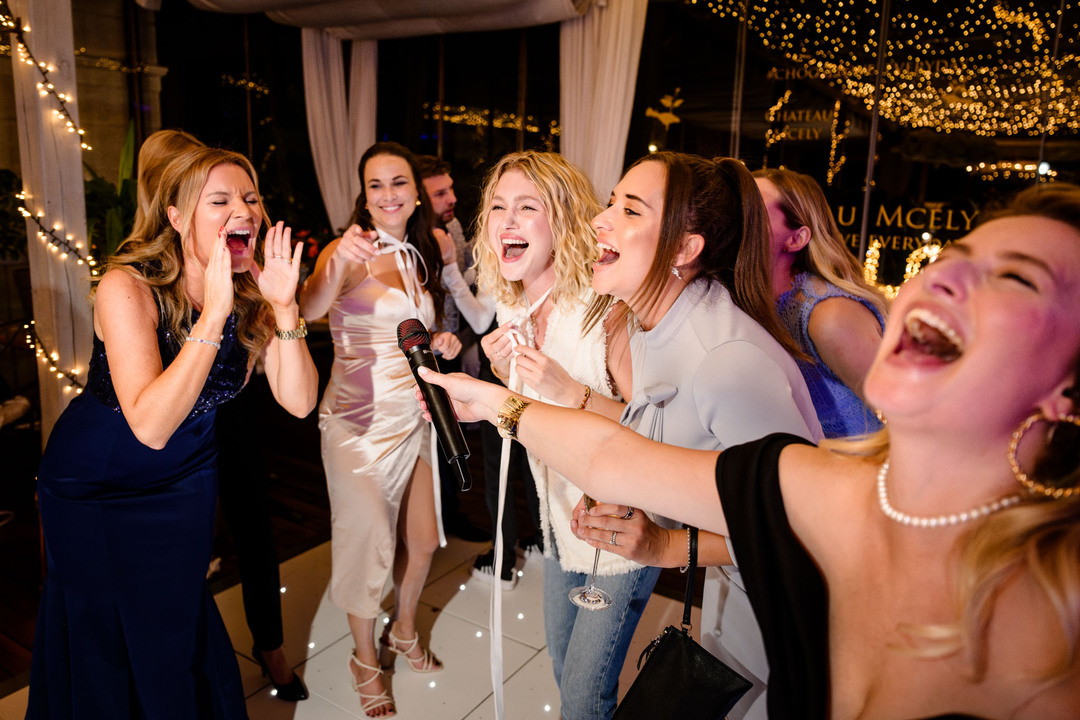 Wedding guests singing and celebrating together at Chateau Mcely, capturing the atmosphere of the wedding party.