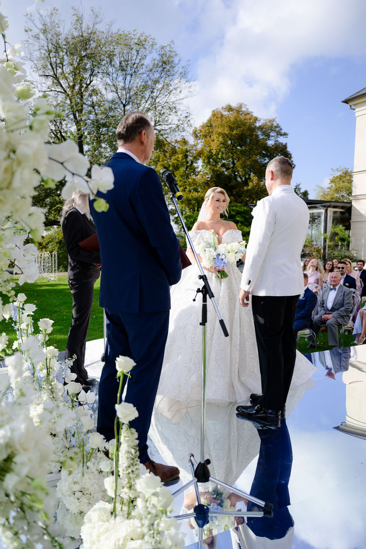 Nevěsta a ženich si vyměňují sliby na krásně vyzdobeném venkovním obřadu na Chateau Mcely.