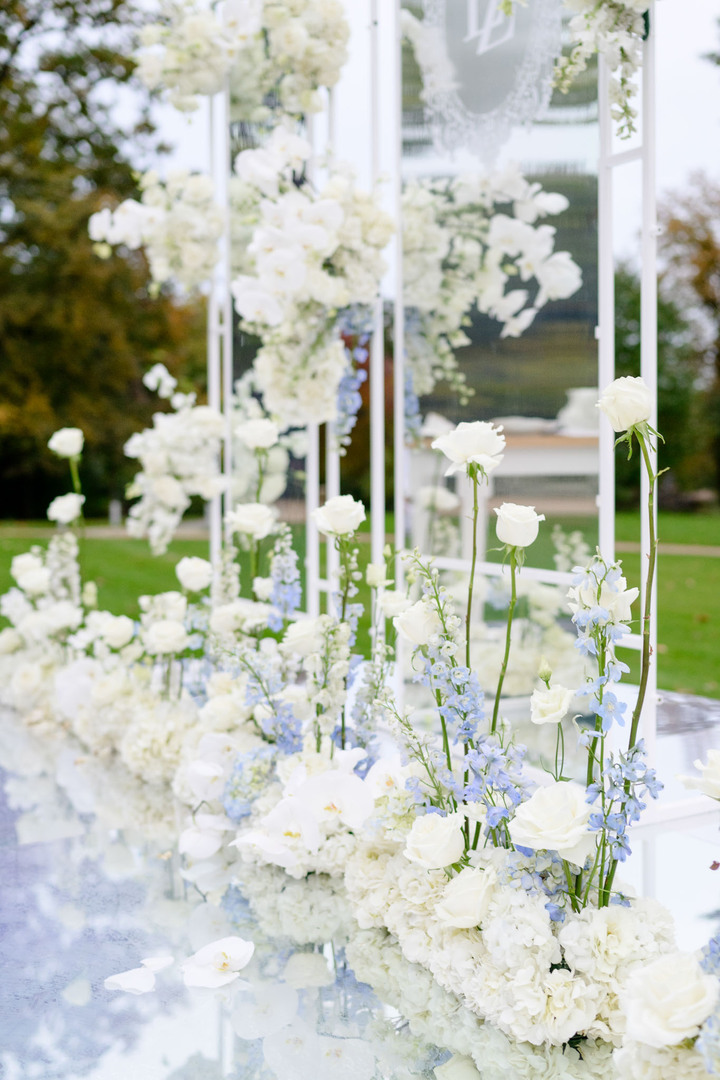 Elegant wedding aisle decorated with white and blue flowers and transparent stands at Chateau Mcely.