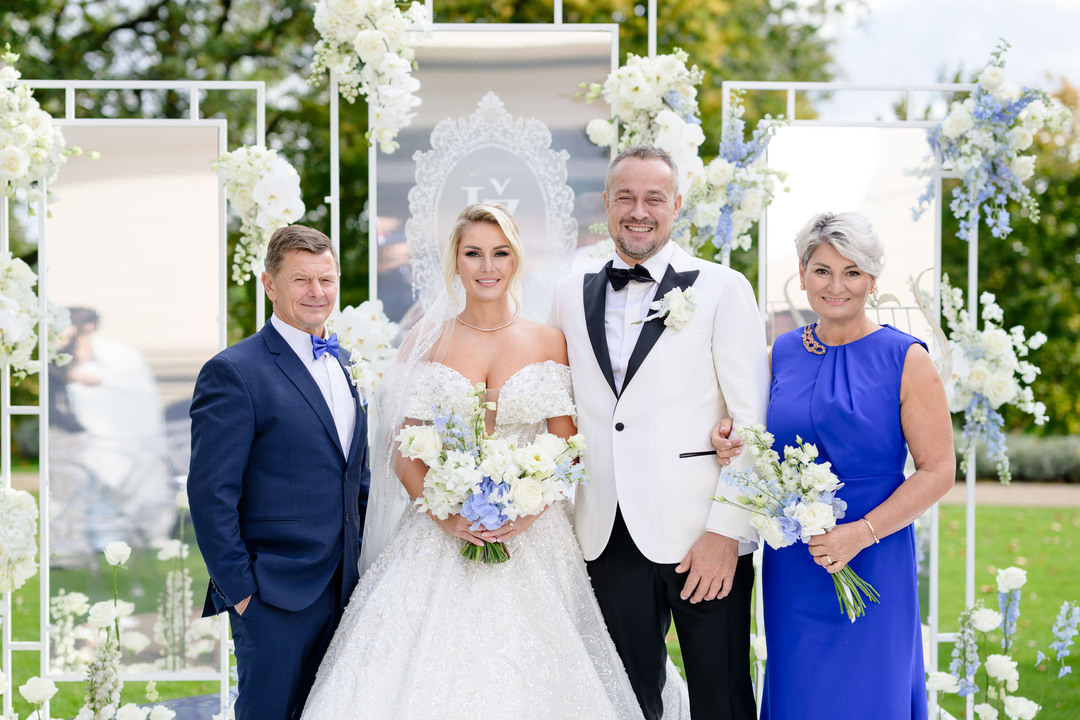 Bride and groom with family at Chateau Mcely's opulent wedding setting.