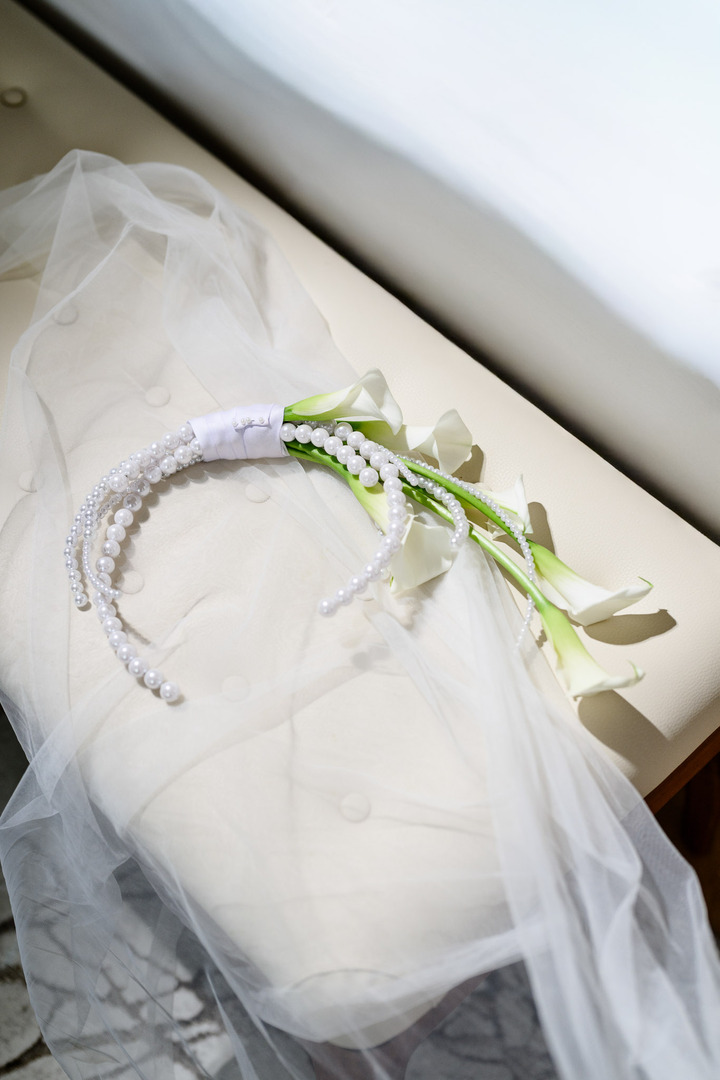 A modern bridal bouquet – tied white lilies paired with pearl headbands.
