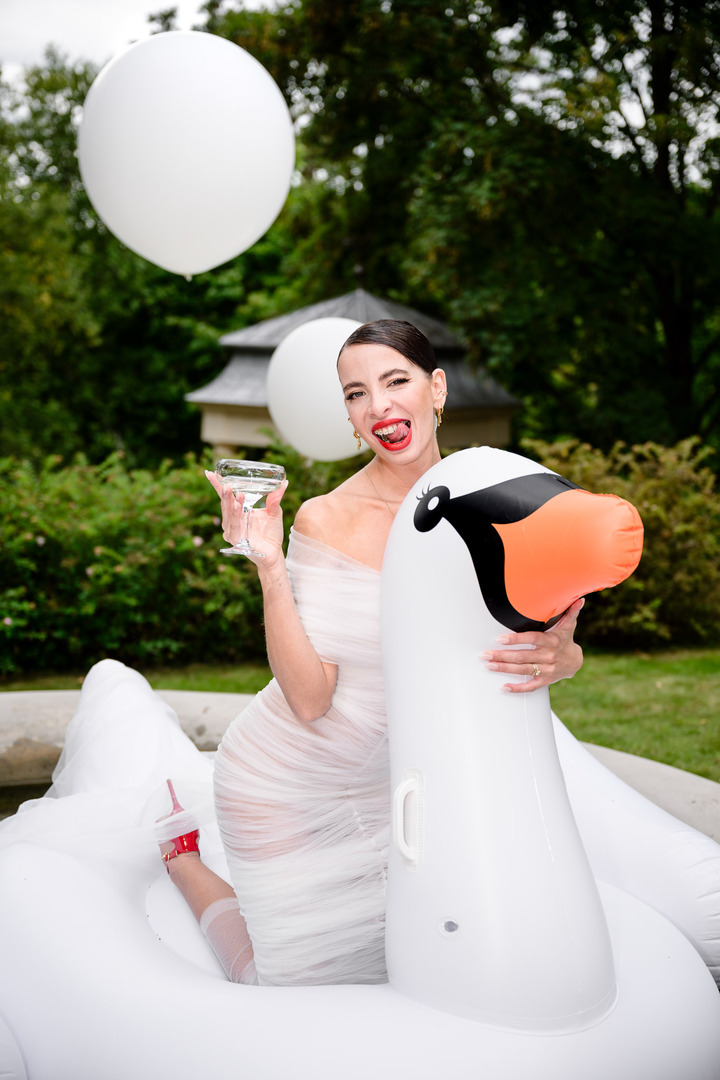 Fashion designer Debbie Brown with champagne on an inflatable swan during her wedding in Karlovy Vary.
