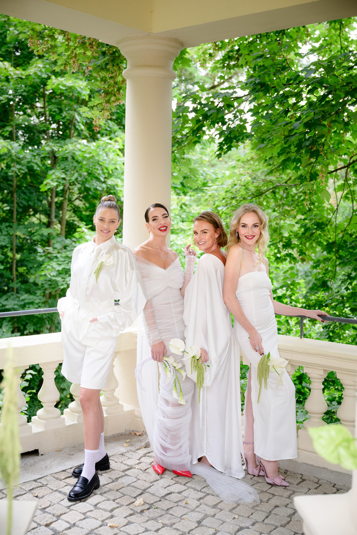 Fashion designer Debbie Brown with her bridesmaids in elegant white dresses.
