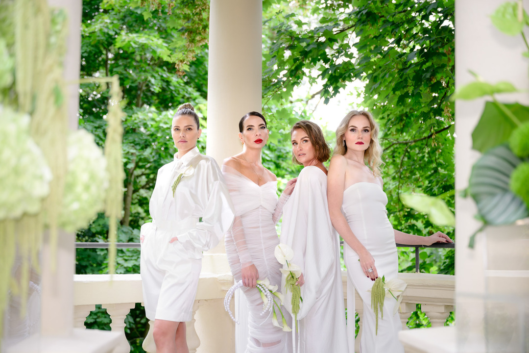 Designer Debbie Brown poses with her bridesmaids in stylish white dresses.
