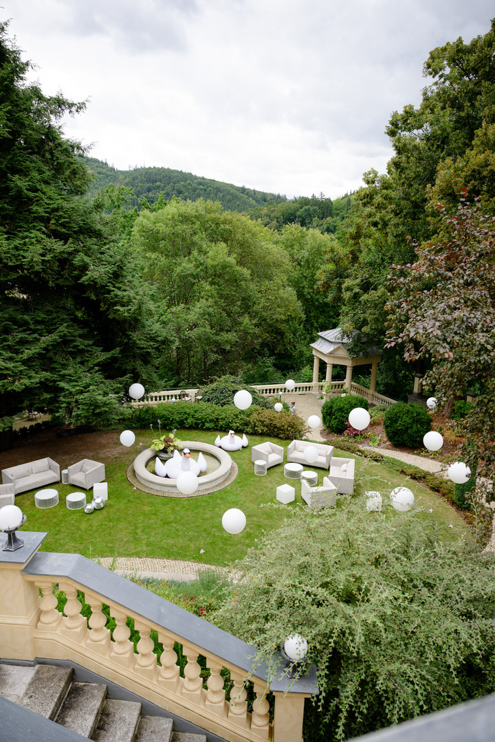 Villa Julius & Emma P. in Karlovy Vary, with a view of the garden decorated with white balloons, and a wedding gazebo prepared in the background.
