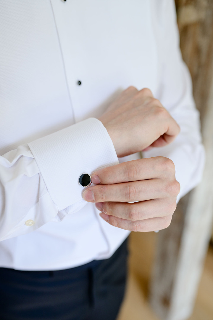 Detail photograph of the groom getting dressed.
