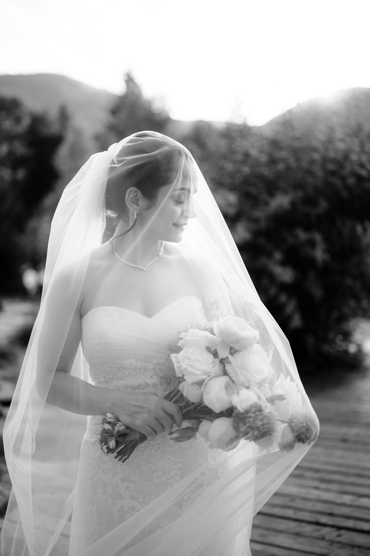 Timeless elegance: Bride in a flowing lace gown, holding a delicate bouquet of roses, her veil softly floating in the mountain breeze – a dreamy wedding moment at Hotel U Holubů, Čeladná, Beskydy.