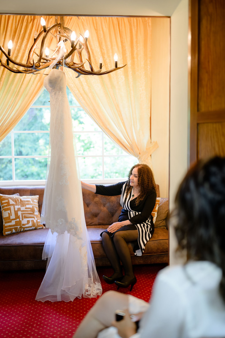 Wedding morning at Hotel & Garden U Holubů, mother admiring the wedding dress.
