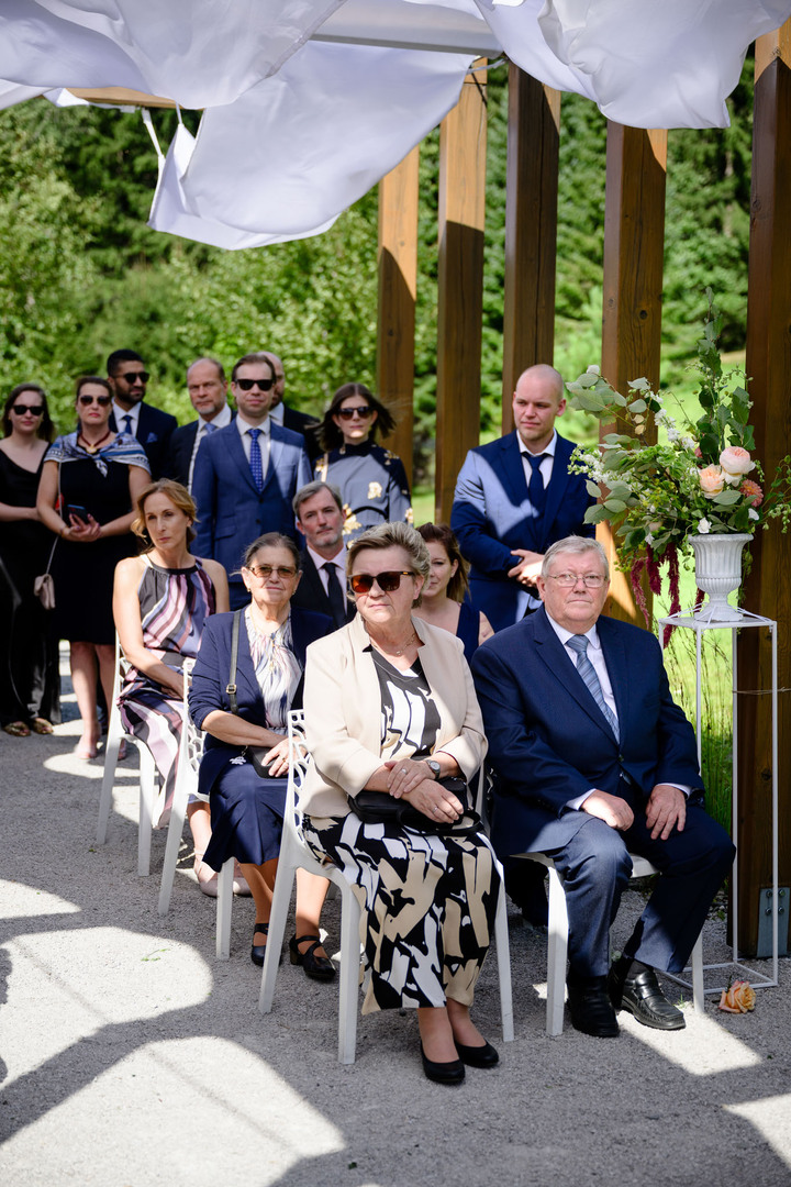 Wedding guests sitting and standing, part of the ceremony.

