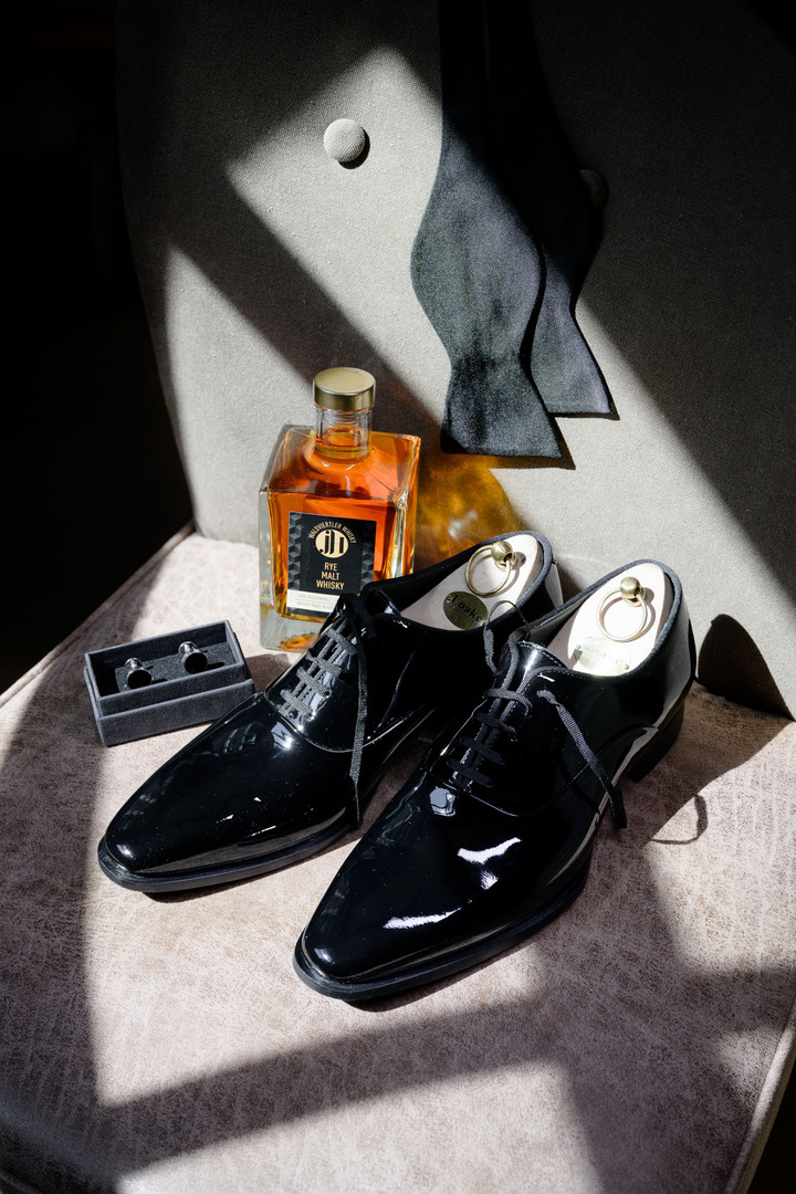 Detail photographs of groom’s accessories, polished shoes, perfume and bow tie by photographer Jindřich Nejedlý.
