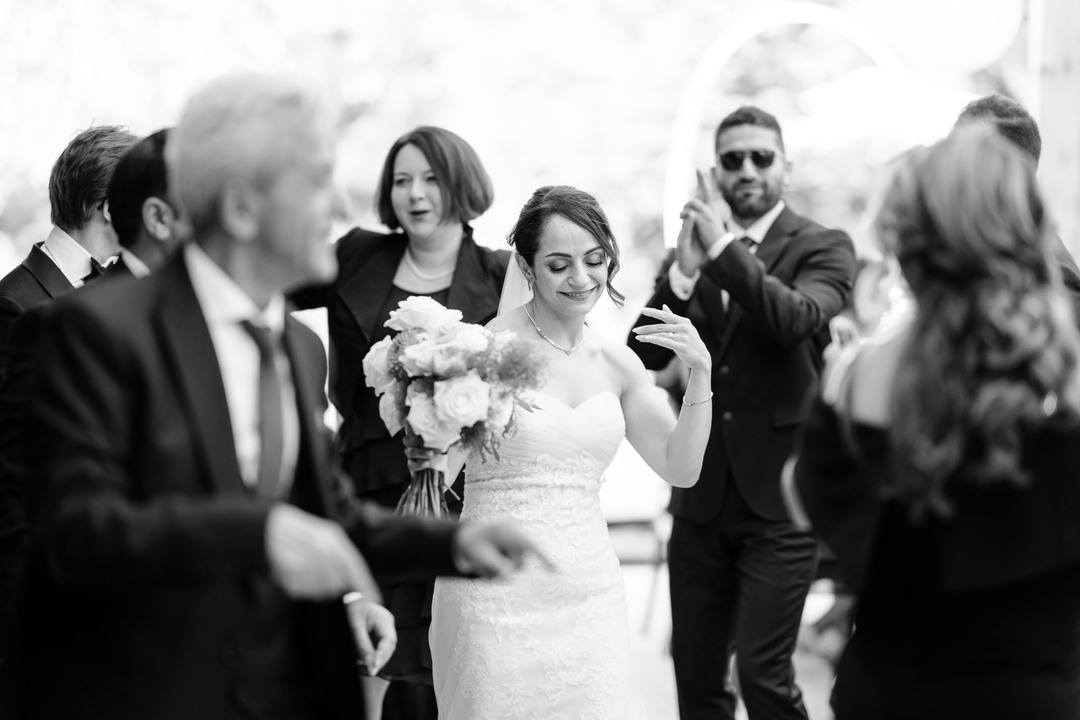 The bride happily dancing surrounded by family and friends, photographed by wedding photographer Jindřich Nejedlý in Čeladná.

