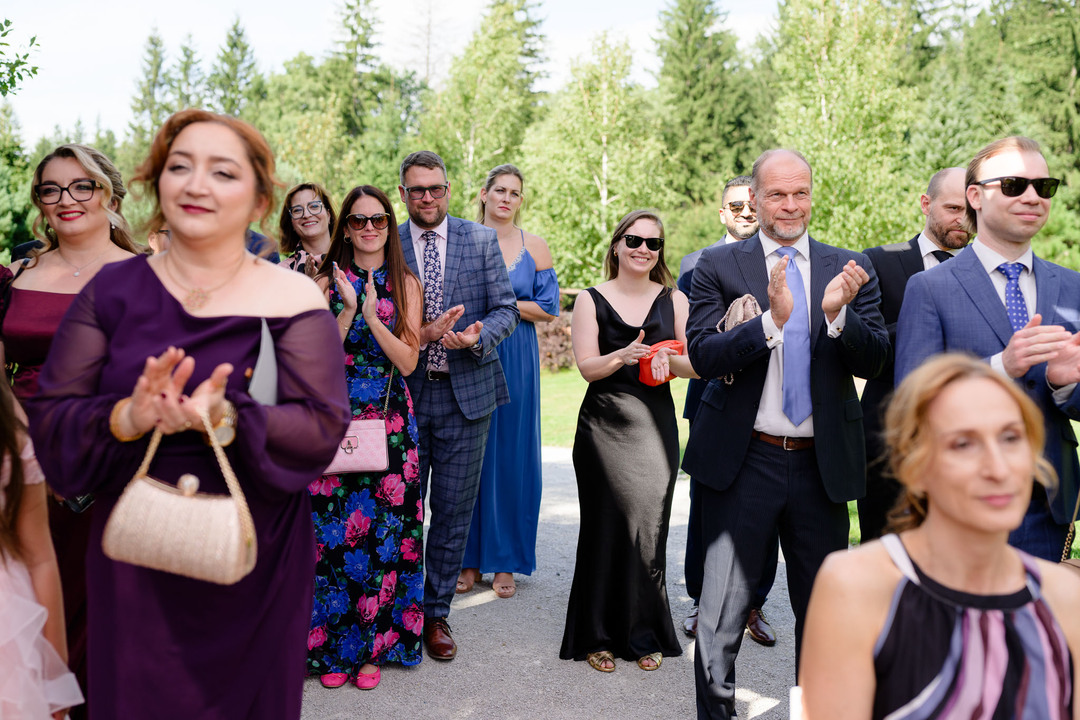 Wedding guests at a summer wedding in the Beskydy, applauding during the ceremony.
