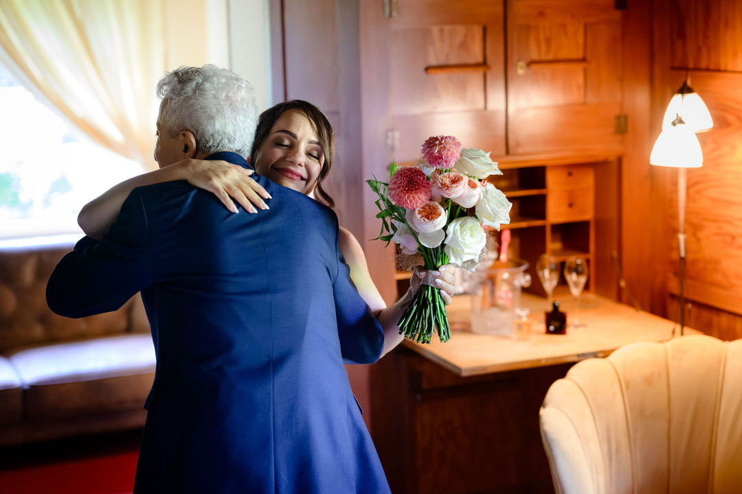 The bride embraces her father, both moved by the moment during a wedding at U Holubů.

