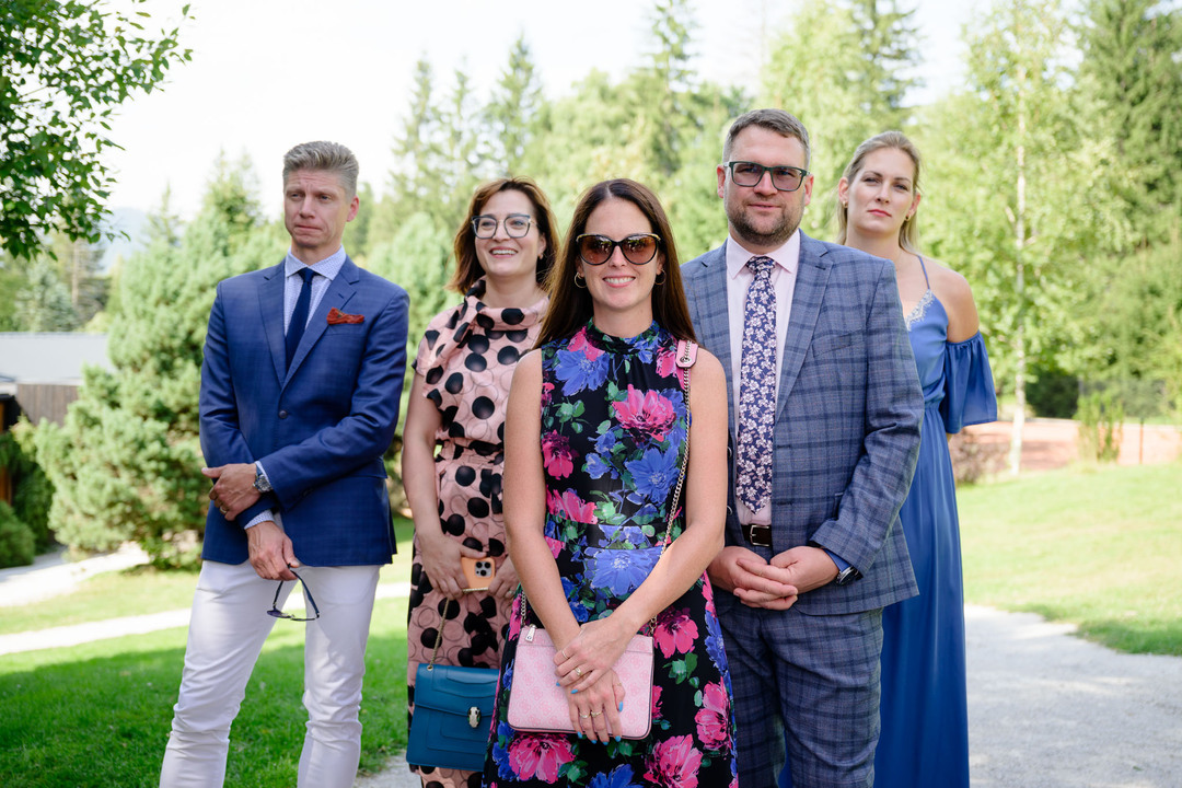 Wedding guests at an outdoor wedding in the Beskydy laughing during the ceremony.
