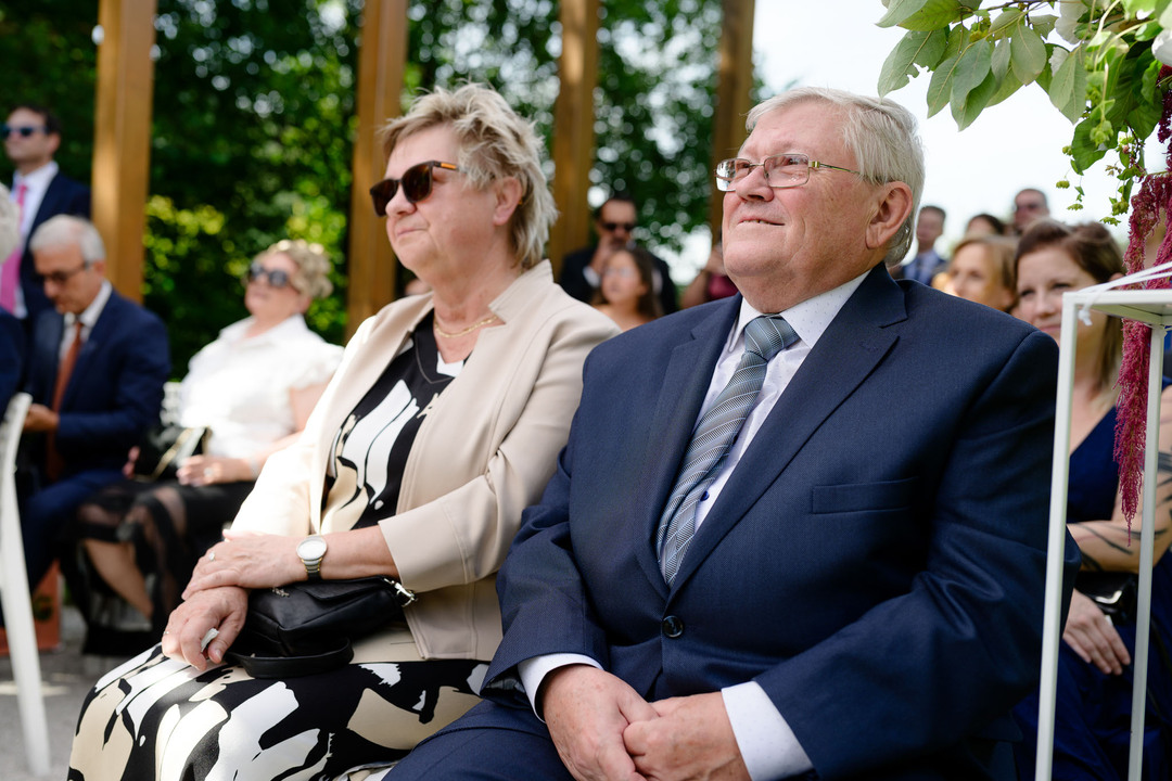 Guests watching an outdoor wedding ceremony.

