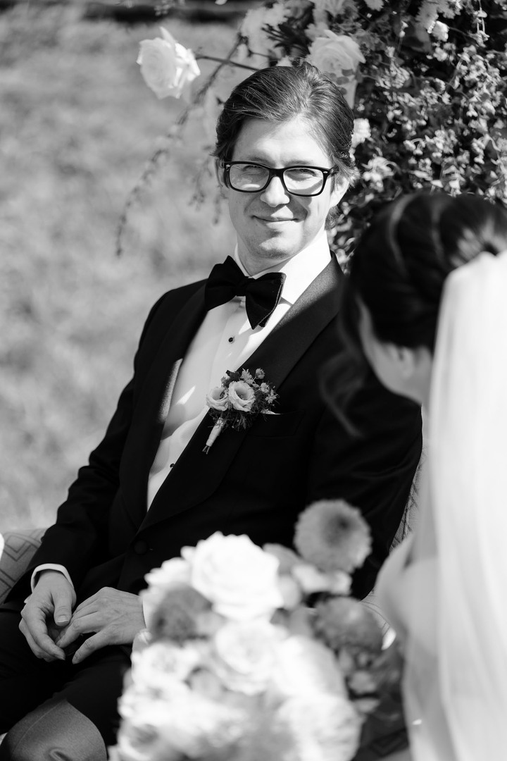 The groom looks lovingly at his future wife during the ceremony in the garden at U Holubů.
