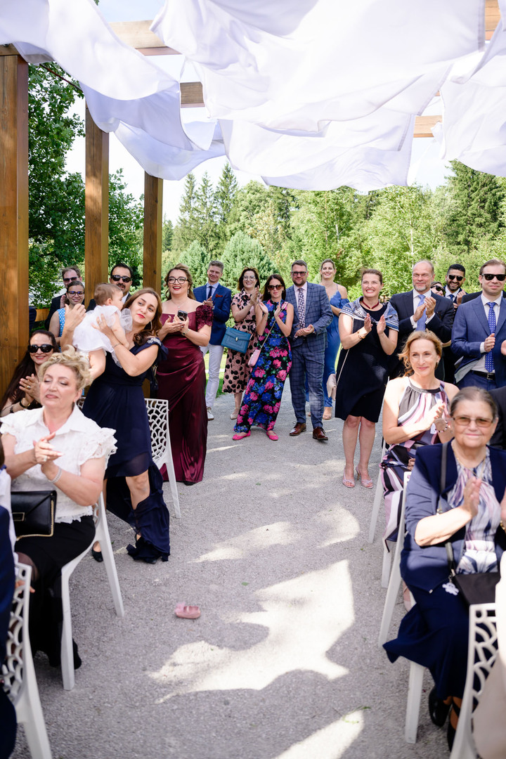 A group of wedding guests during an outdoor ceremony.
