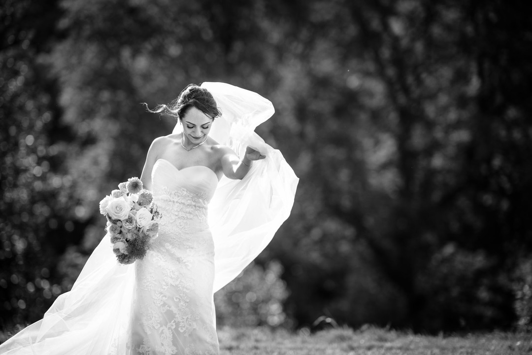 Portrait photograph of the bride with a flowing veil by wedding photographer Jindřich Nejedlý.

