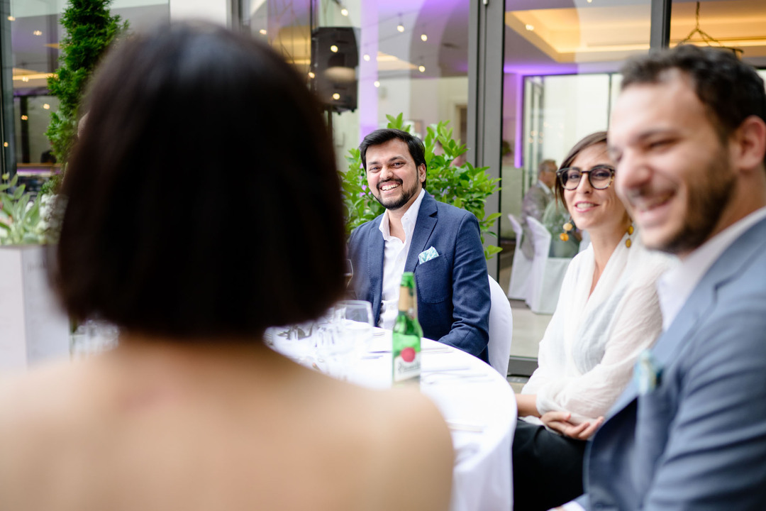 Hosté u stolu se společně baví a vesele se smějí.