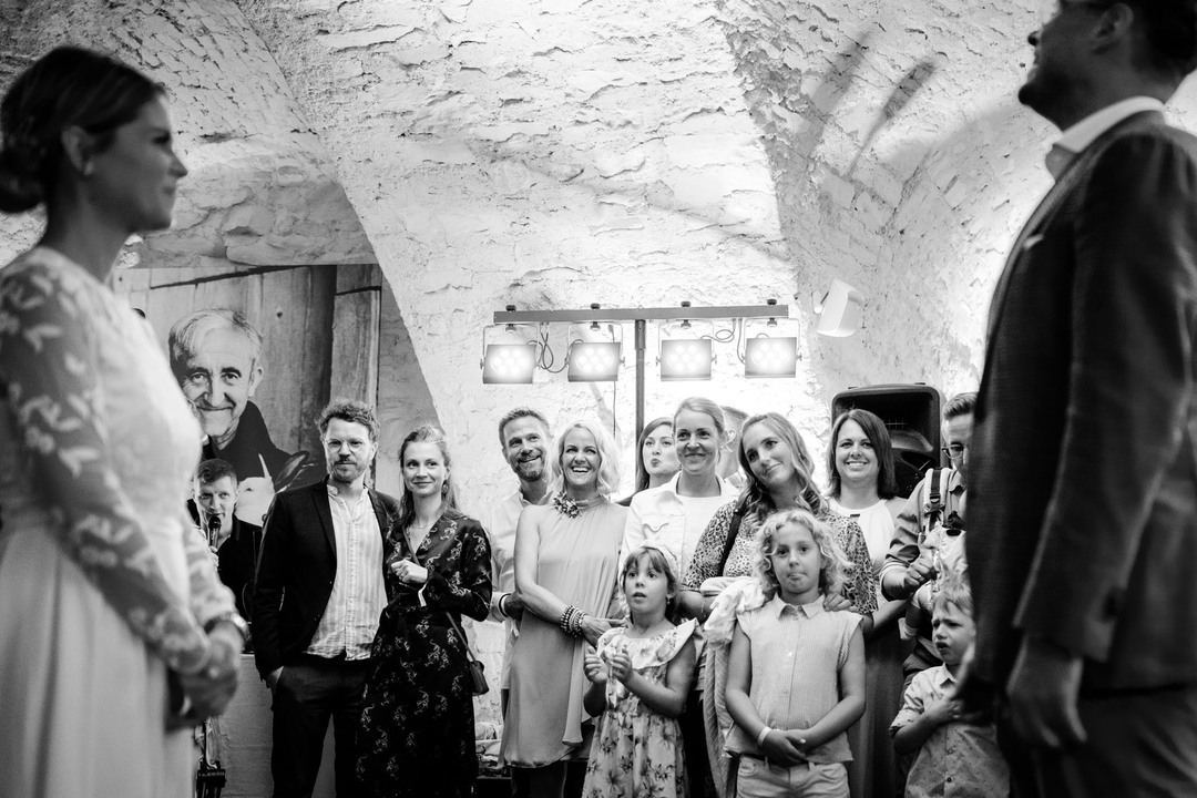 Svatební hosté v Pivnici U sv. Tomáše pozorují novomanžele při tanci.