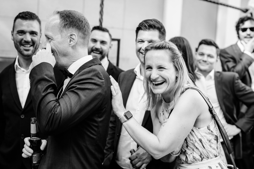 Svatebčané se vesele smějí.