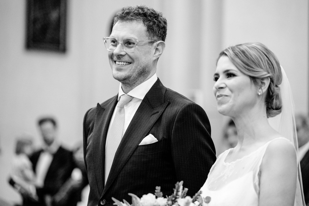 černobílá fotografie zabírající obličeje nevěsty a ženicha, oba se usmívají a vypadají spokojeně.