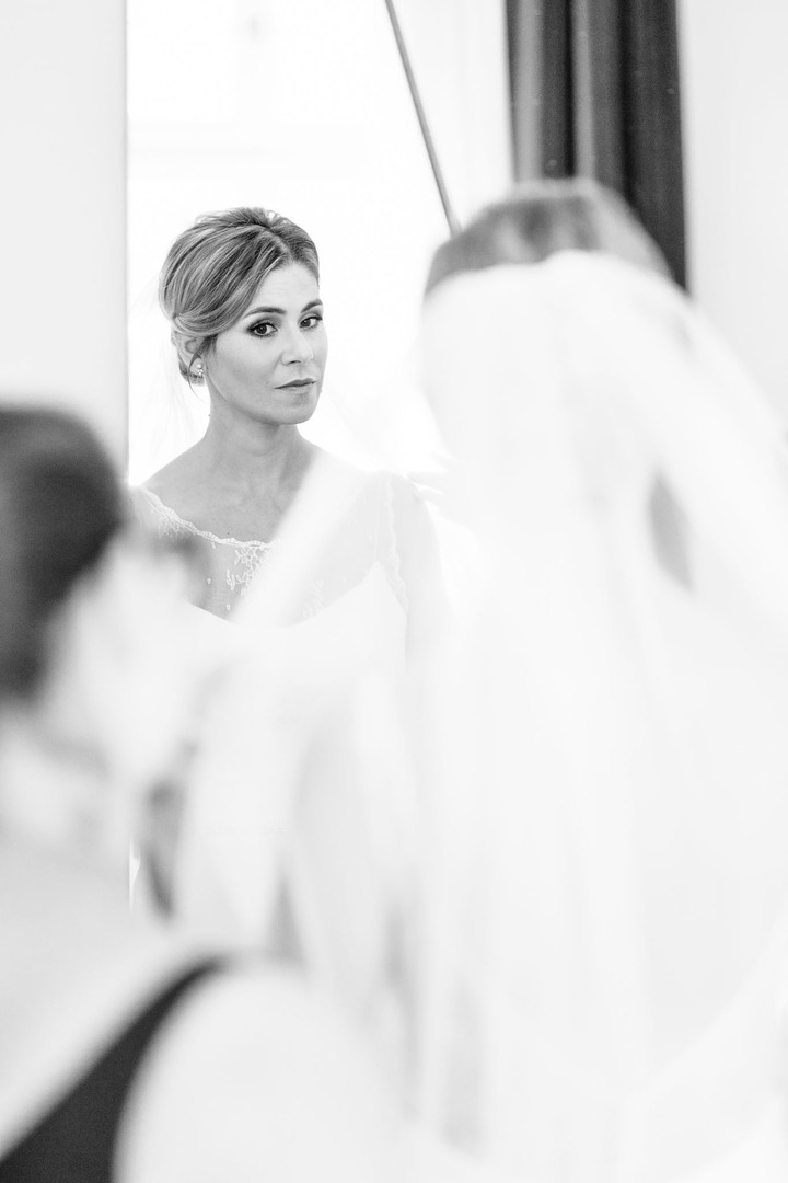 Nevěsta se prohlíží v zrcadle a je připravena na svatební den.