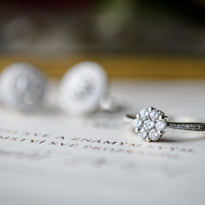 diamond engagement ring on a white paper with diamond earring in a background