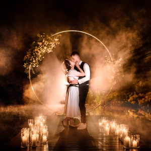 night portrait of bride and groom with candels
