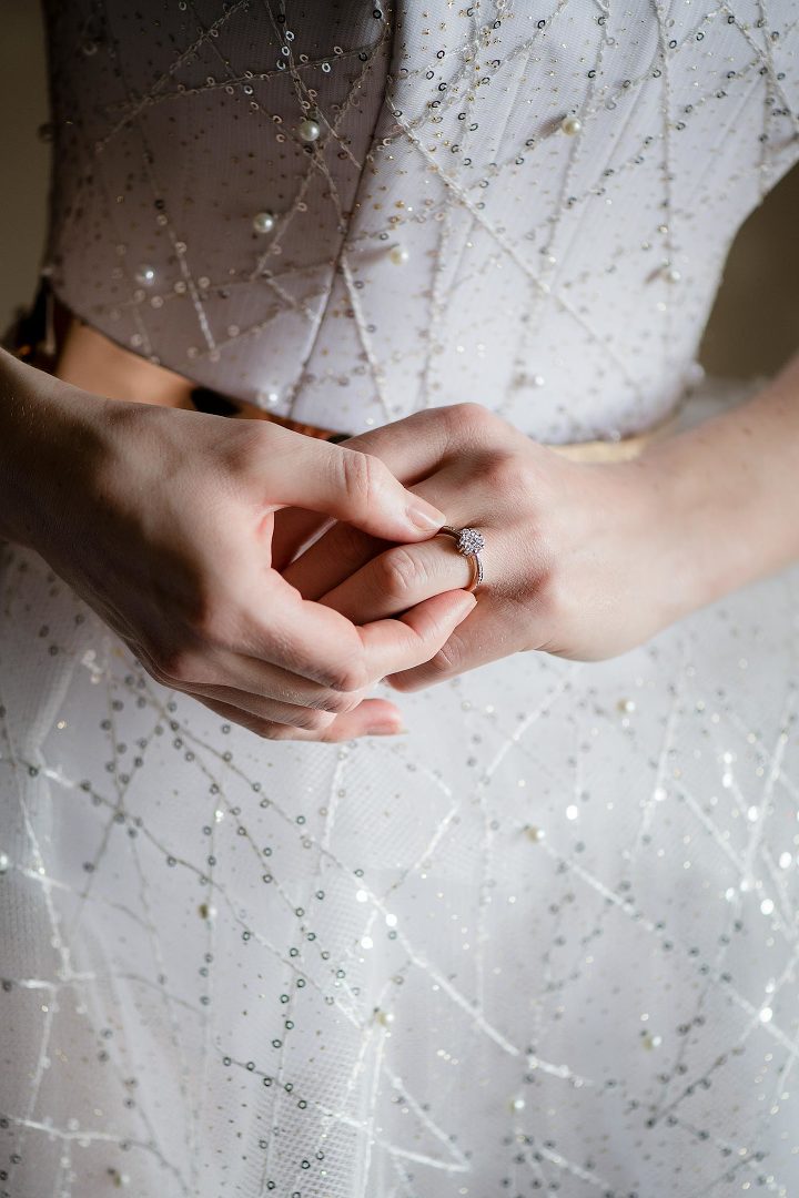 brides hands with diamond ring and white dress