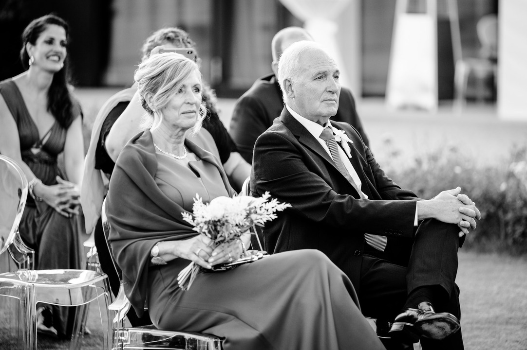 Groom's parents smiling warmly at the Obelisk Winery wedding ceremony.