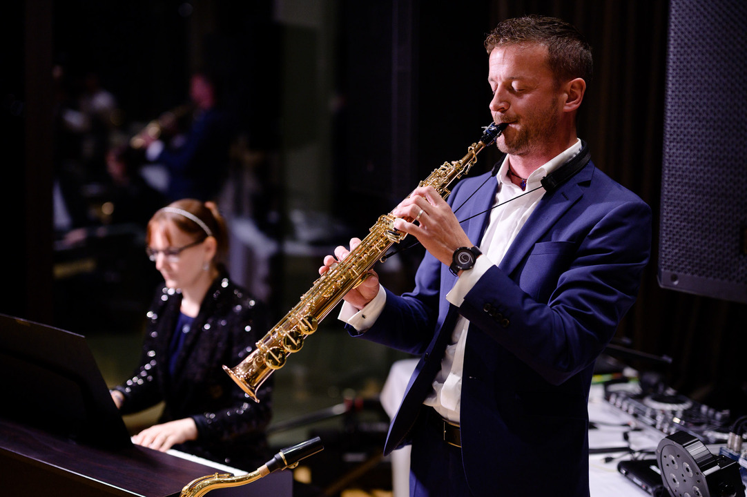 Saxofonista s doprovodem na piano vytváří hudební scénu svatební hostiny.