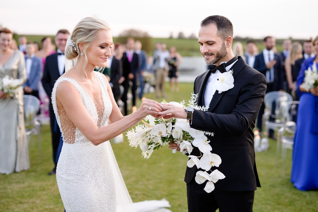 Couple exchanging rings during their wedding ceremony at Obelisk Winery.