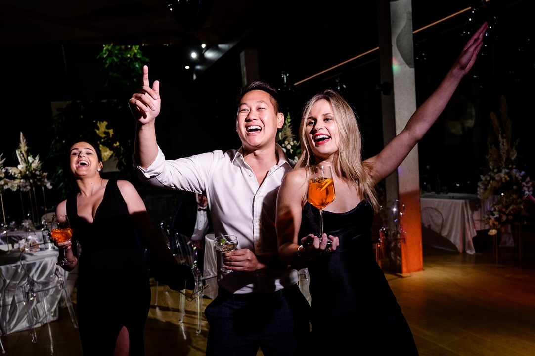 The guests enjoying the evening, dancing with their hand in the air.