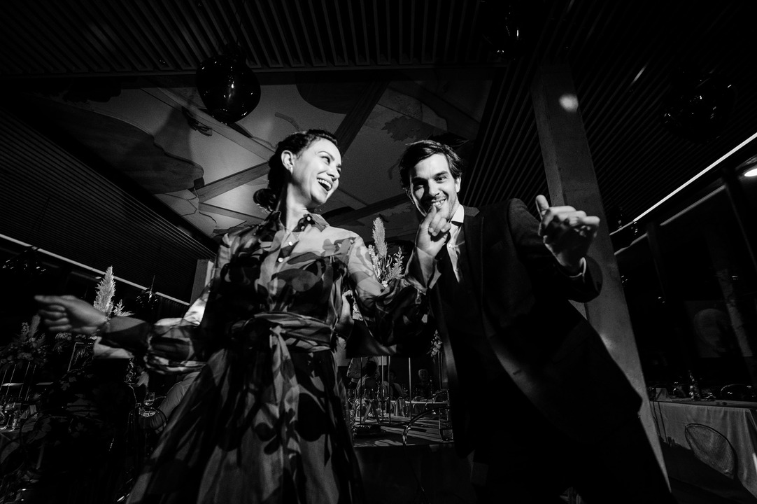 A black-and-white photo of a couple dancing playfully on the dance floor.