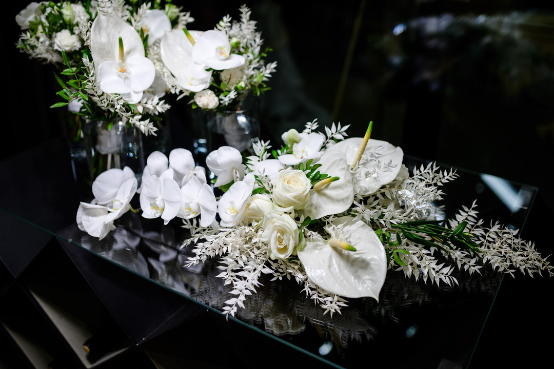 Elegant white floral arrangement on a black table at the Obelisk Winery wedding.