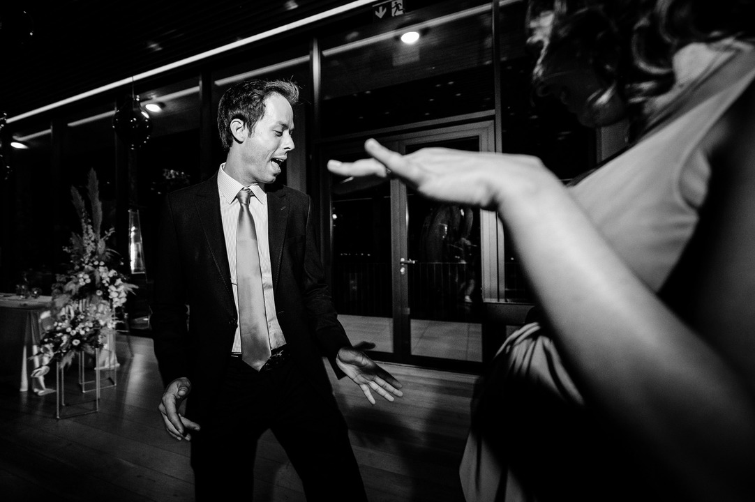 A black-and-white shot of a man enjoying the dance floor atmosphere.