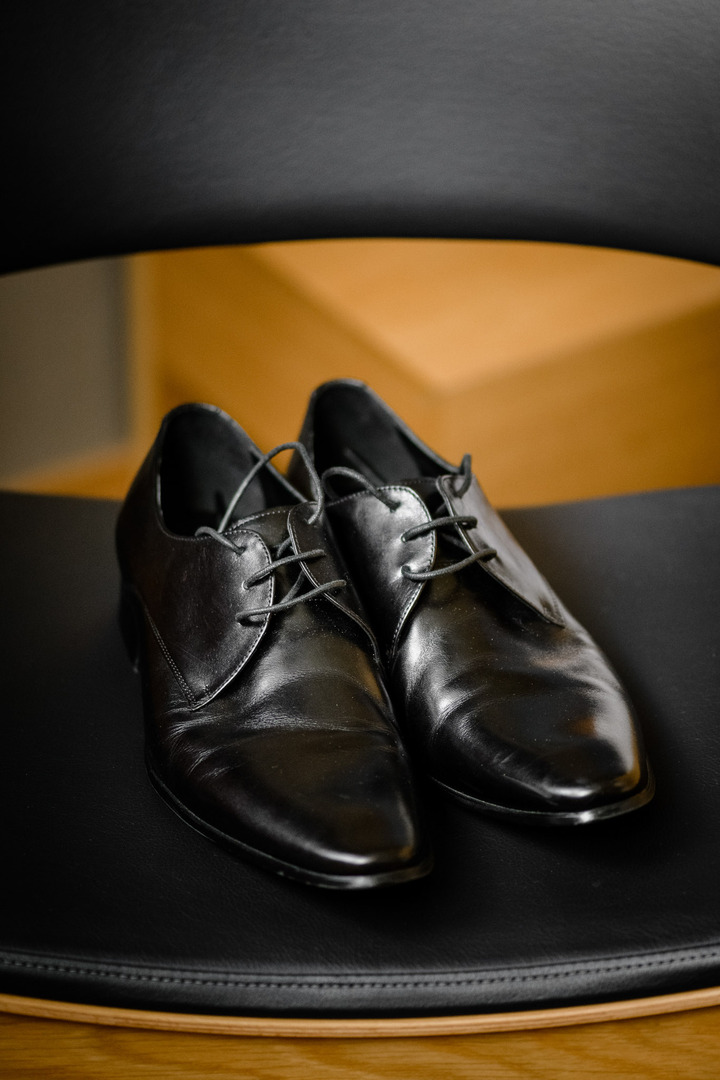 Black leather shoes placed on a chair, ready for the groom.