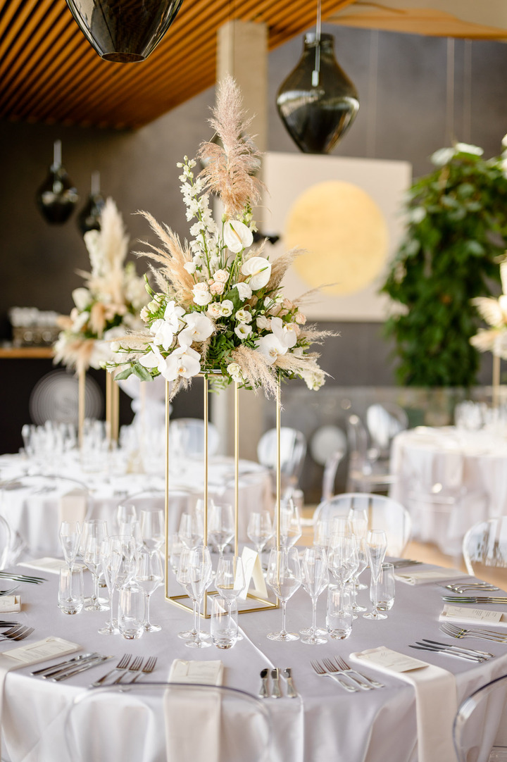 Elegant wedding reception setup with white floral centerpieces and greenery at Obelisk Winery.