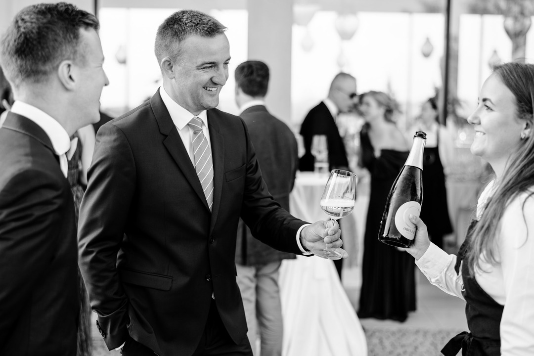 Guests have wine poured by the sommelier.